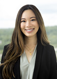 Aurelia is wearing a black blazer and seafoam green blouse.