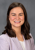 Diana is wearing a lavender blazer and white blouse.