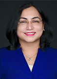Divya is wearing a blue jacket with a white shirt.