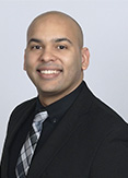 Pablo is wearing a black shirt with a black/gray tie. 