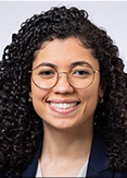 Jeslyn Rodriguez has long curly black hair and circuluar glasses.