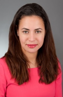 Catherine A. Brownstein has long brown hair. She is wearing a pink shirt.