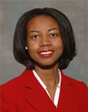 Cheryl R. Clark has short black hair. She is wearing a red blazer and white shirt.