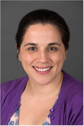 Gabriela Vargas is wearing a purple cardigan and patterned shirt.