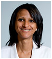 Patricia Sylla has medium length black hair. She is wearing a white coat.