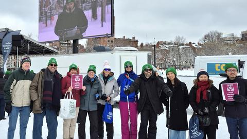 The 2025 Harvard Longwood Campus team stands bundled up in the snow on the Boston Common.