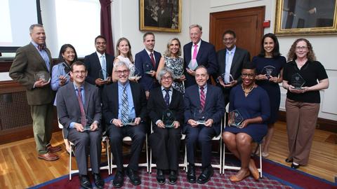 2026 Excellence in Mentoring Awards recipients line up for a photo in the Waterhouse Room. They are all holding their angular glass awards.