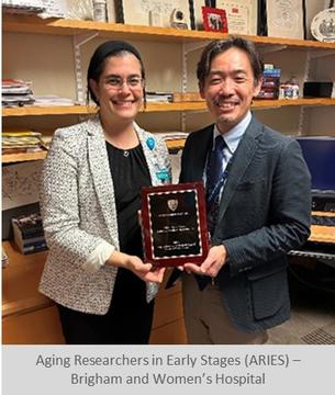ARIES program leaders hold their award as they stand in an office.