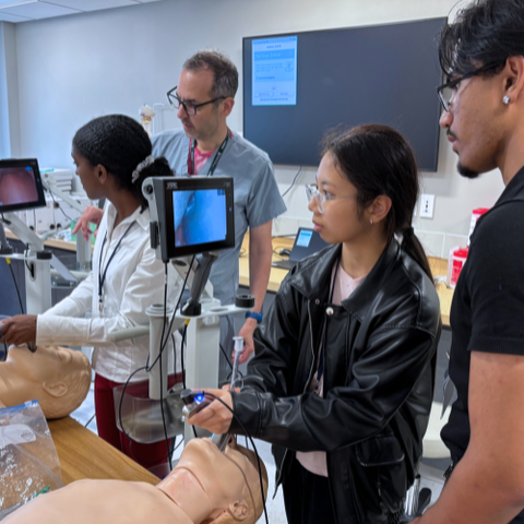 A group of Project Success student examine dummies with scanners.