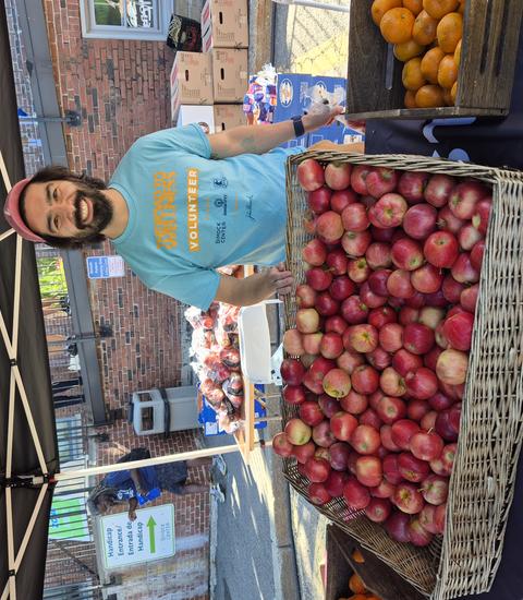 David Choy Buentello stands behind a large basket of apples to hand out to racers.