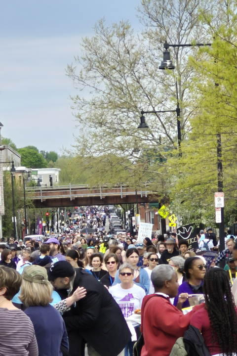 A crowd of people are on a street in Dorchester during the Mother's Day Walk.
