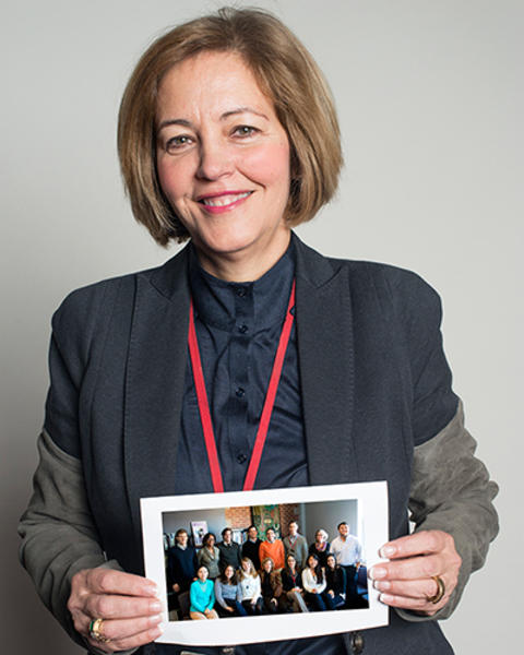 Margarita Alegria holds photo of a group of people.