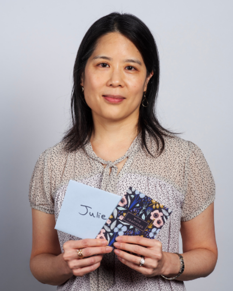 Julie Huang is holding a card and envelope addressed to her.