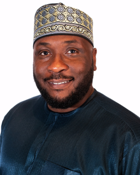 Ahmed Mohammed is wearing a traditional Nigerian kaftan in blue and hat which is yellow and blue patterned.