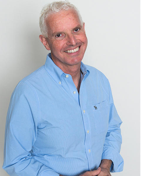 Tomas Kirchhausen is wearing a light blue button-down shirt and jeans. He has his arms clasped in front of him.