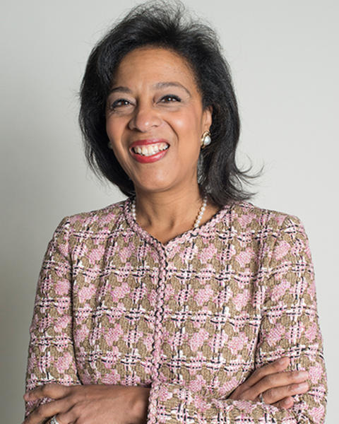 Tina Young Poussaint is wearing a pink and brown knitted jacket.