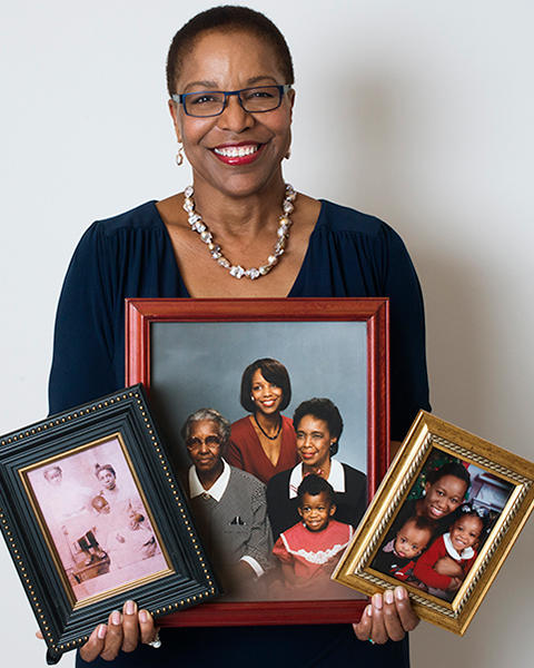 Joan Reede is holding three frames of family members, from her grandmother to two of her grandkids.