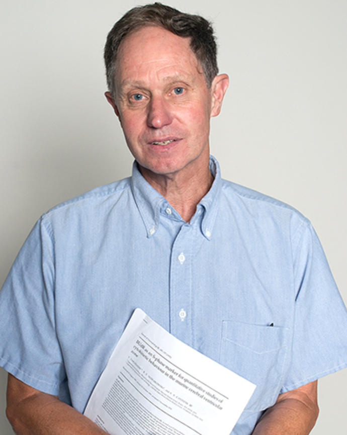 David Lopes Cardozo is holding a printed copy of a research paper. 