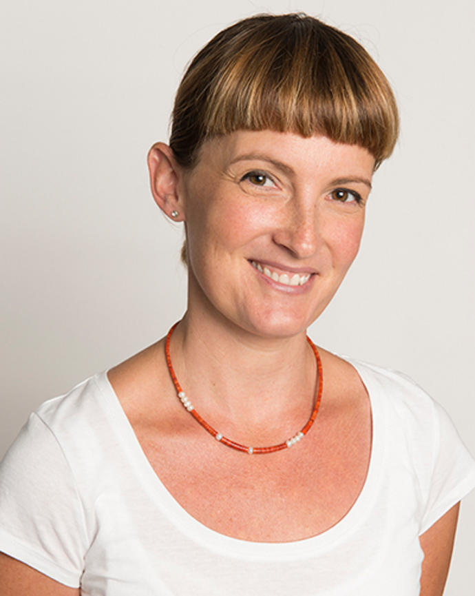 Lisa Derendord is wearing a white shirt and red and white beaded necklace.