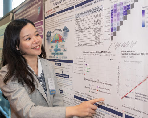 A NESS presenter points to her research poster.